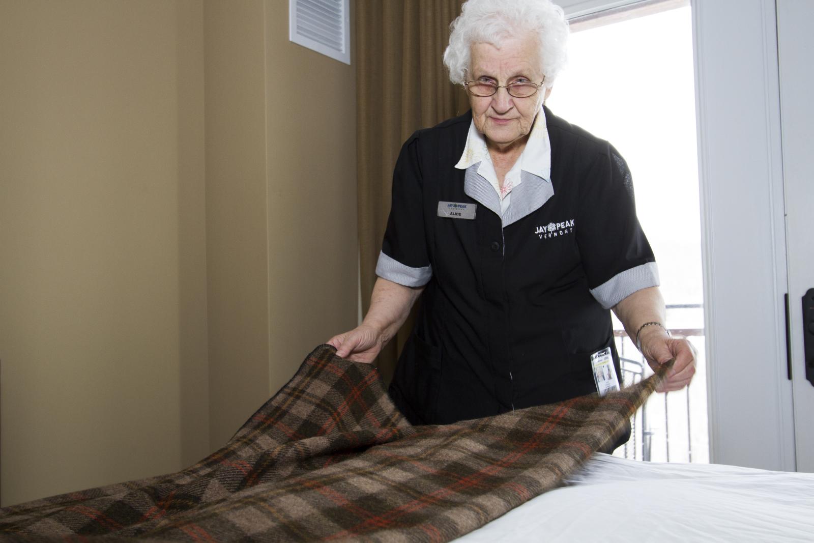 Alice folding a blanket while staring the photographer down. 