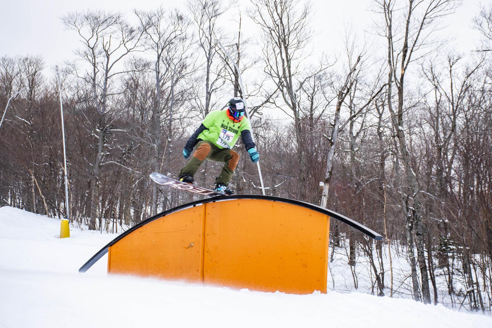 Snowboarder on rainbow bridge rail