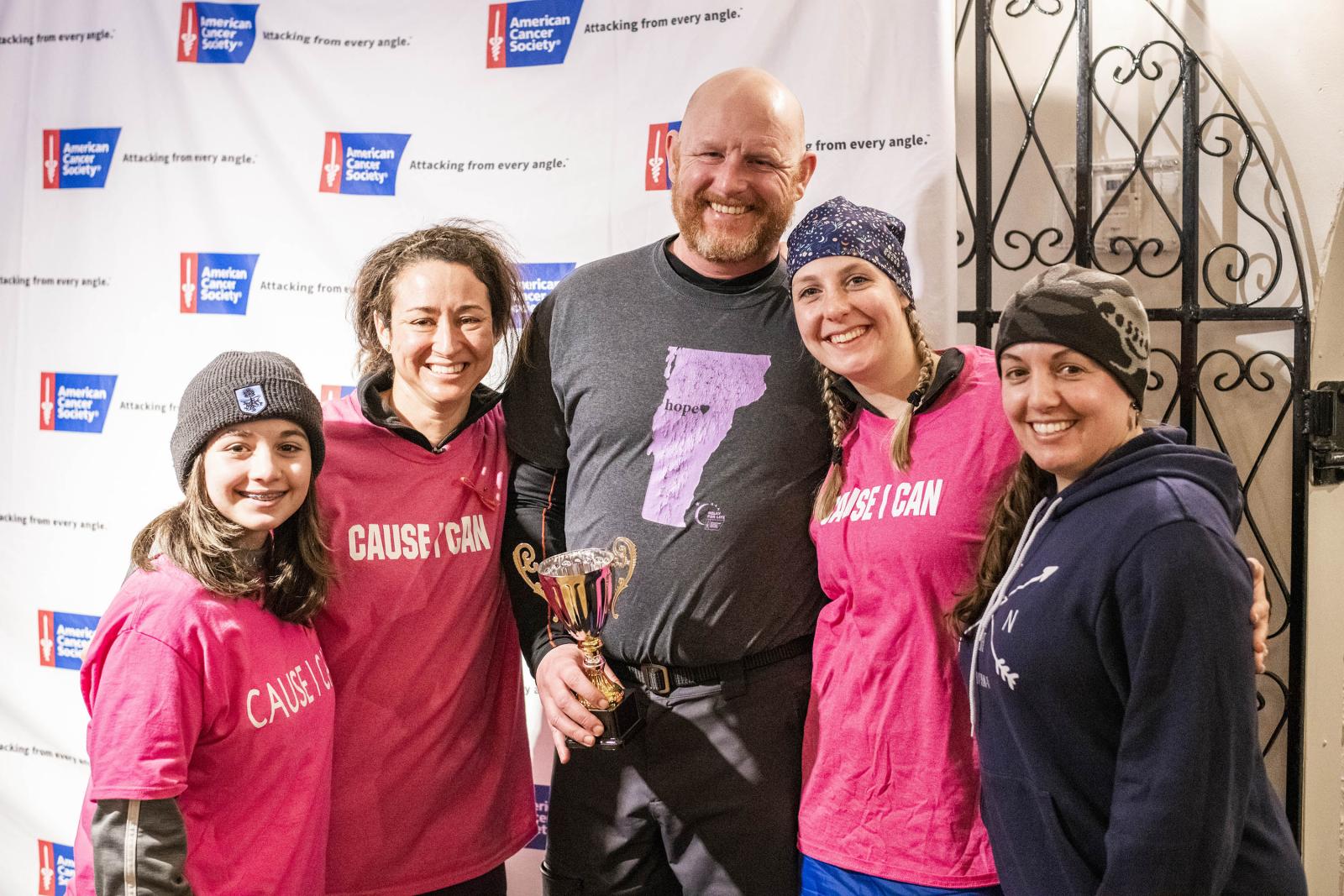 team members smiling in front of ACS backdrop 