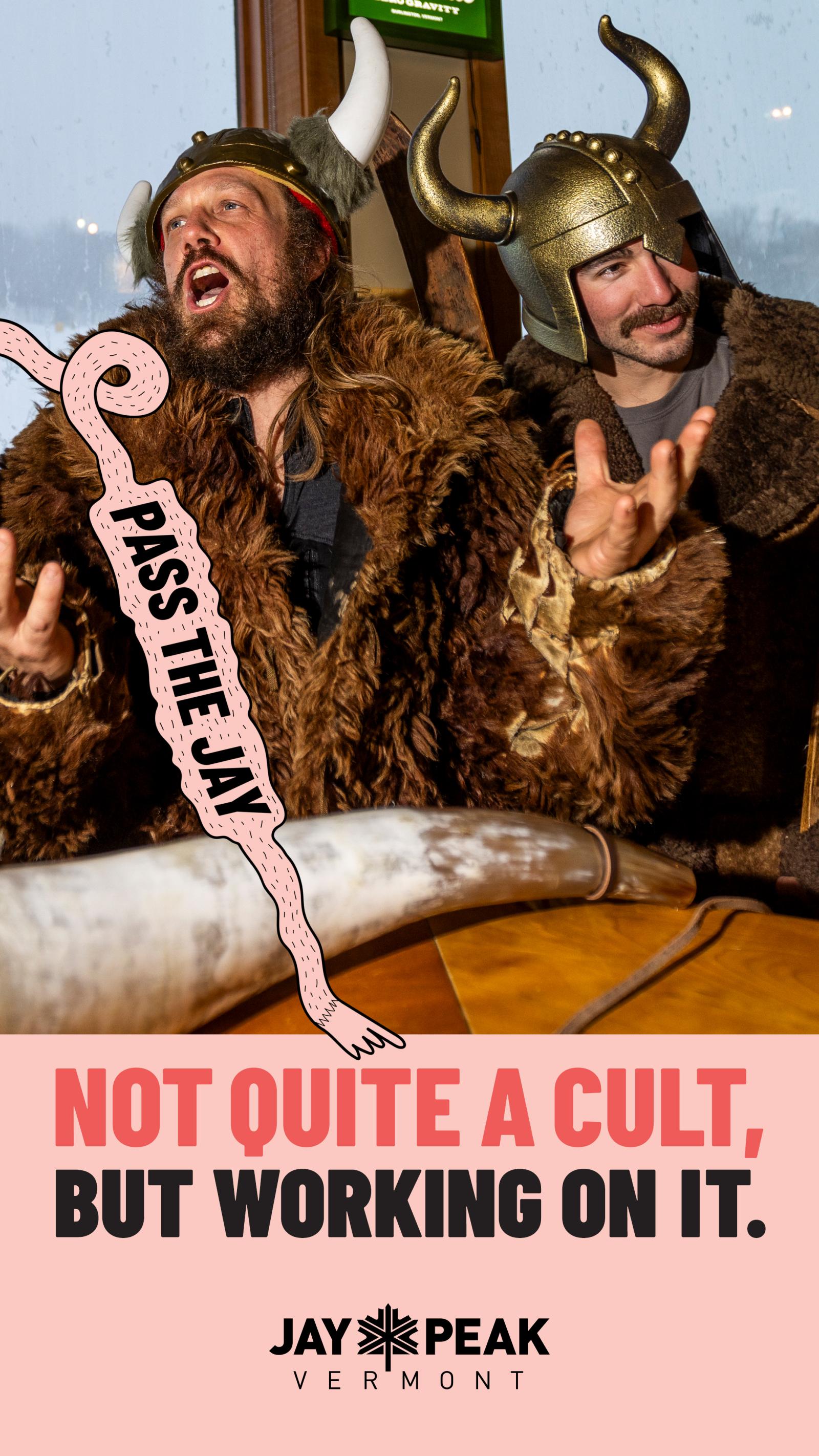 Two people in Viking costumes, one laughing, one smiling, indoors. Jay Peak Vermont logo below.