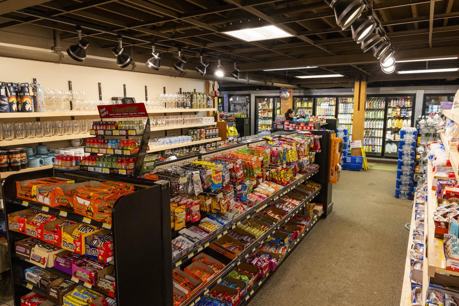 Convenience store aisle with snacks and drinks on shelves.