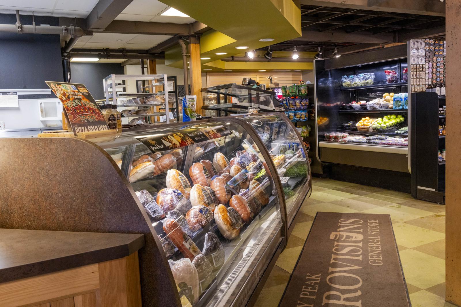 Bakery display with assorted bread and pastries inside a cozy shop setting.