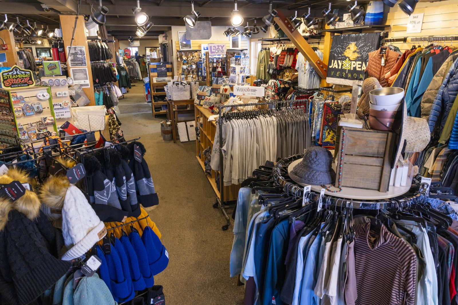 Clothing and accessory store with racks of hats and jackets, bright lighting.