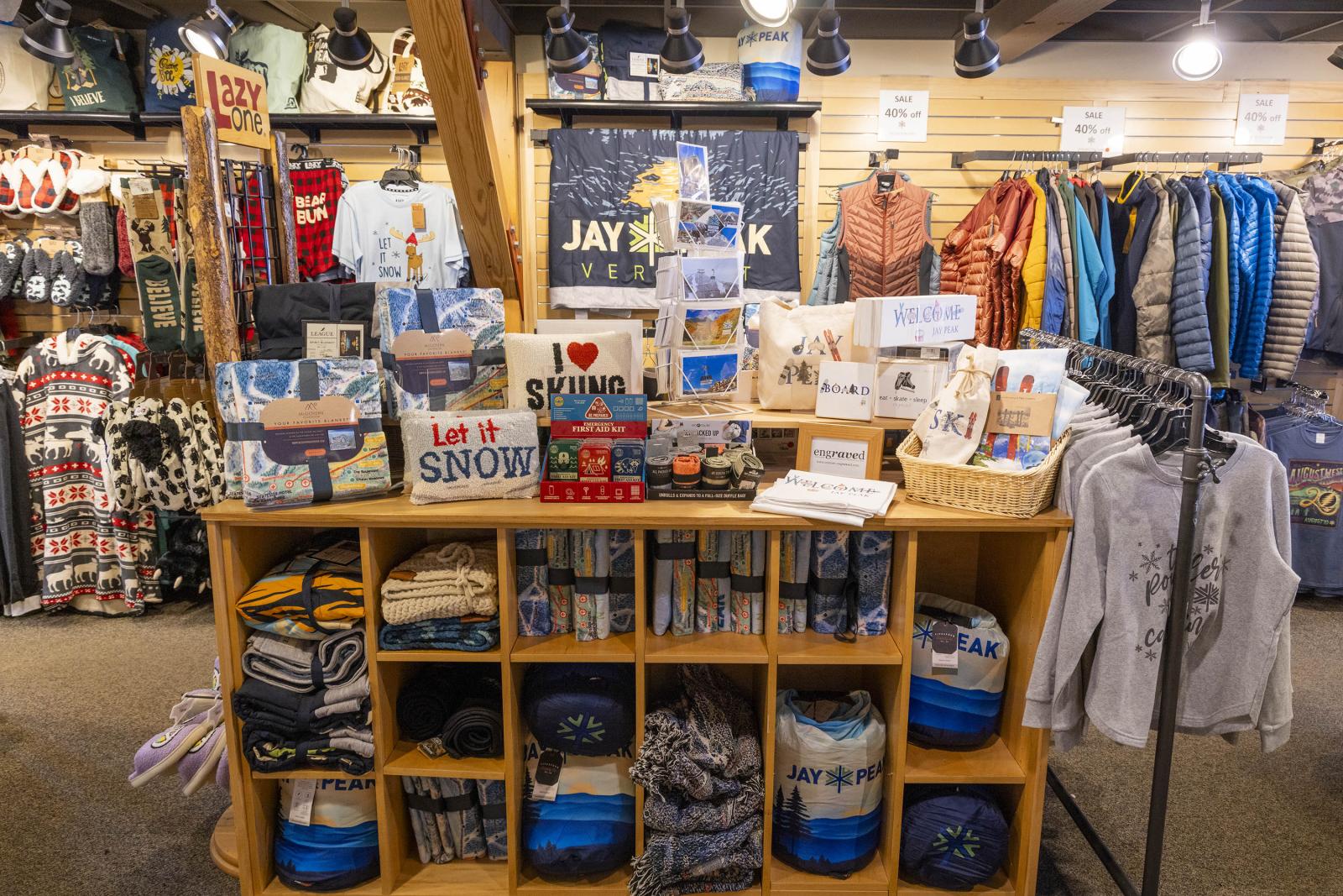 Shop interior with shelves of souvenirs and clothing displays.