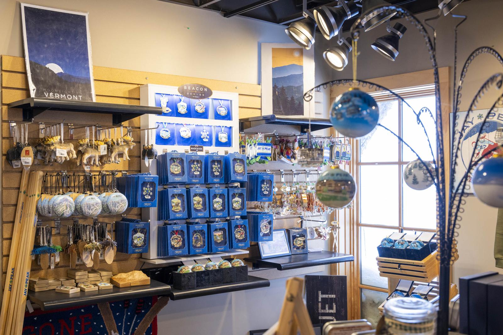 Gift shop display with mugs, ornaments, and globes on shelves.
