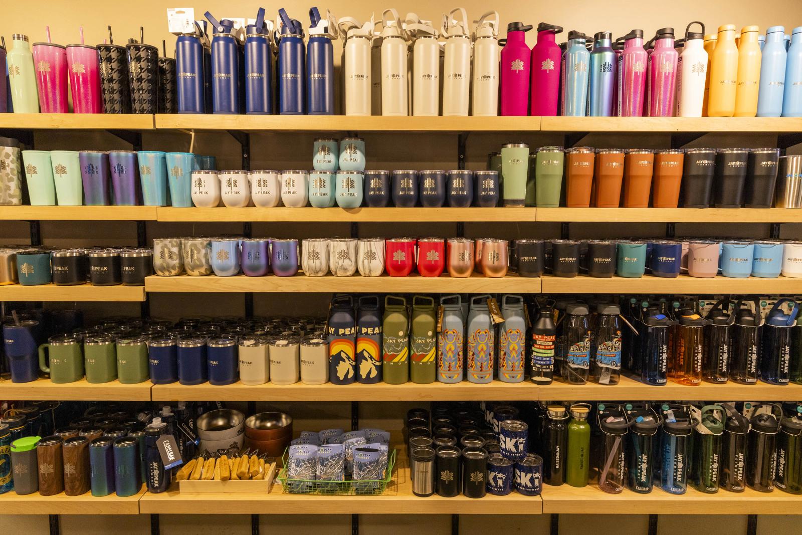 A display of colorful water bottles on shelves.
