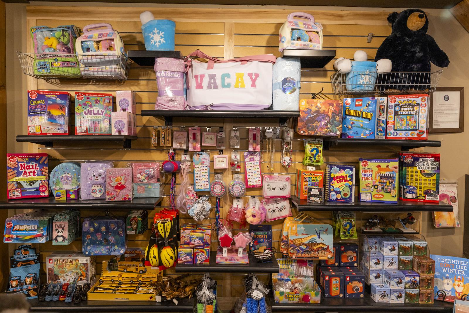 Toy store display with colorful games, plush toys, and gift items on shelves.