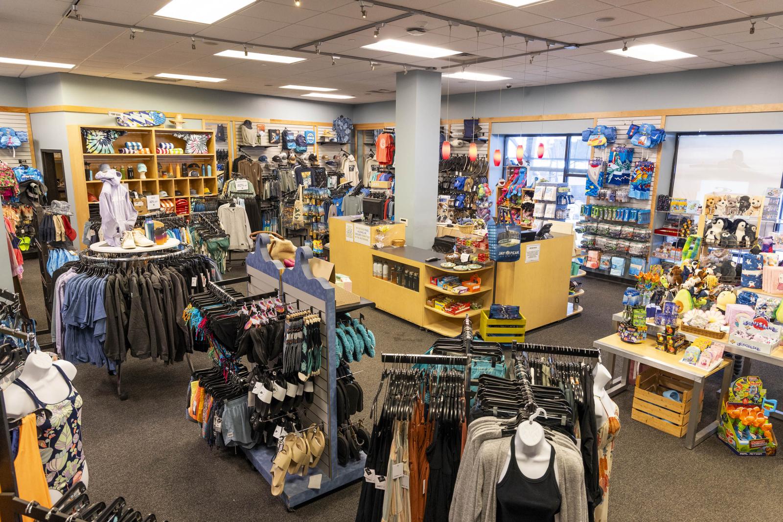A well-organized clothing and gift store with racks and shelves neatly arranged.