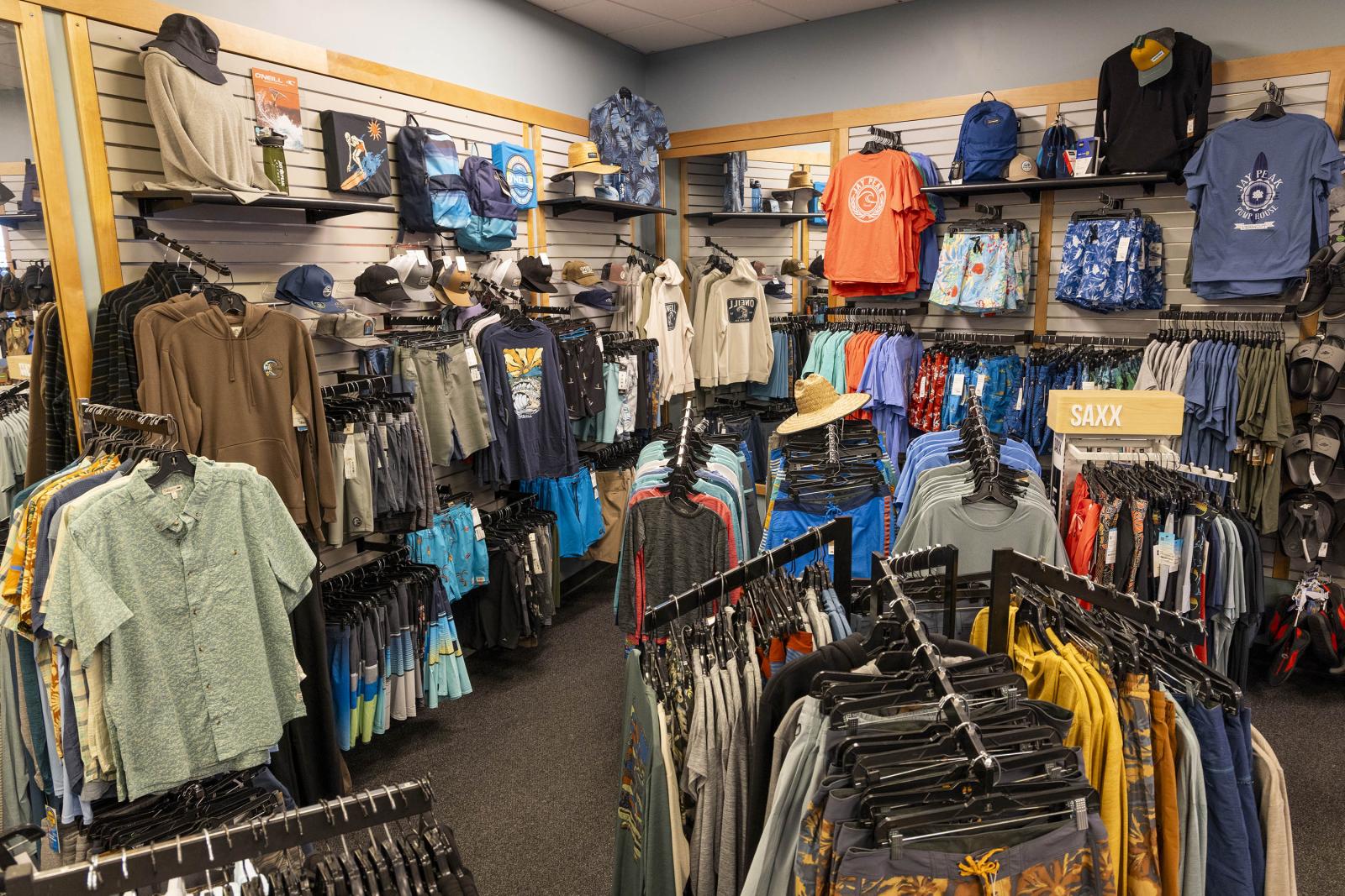 Clothing store with racks of colorful shirts and jackets.