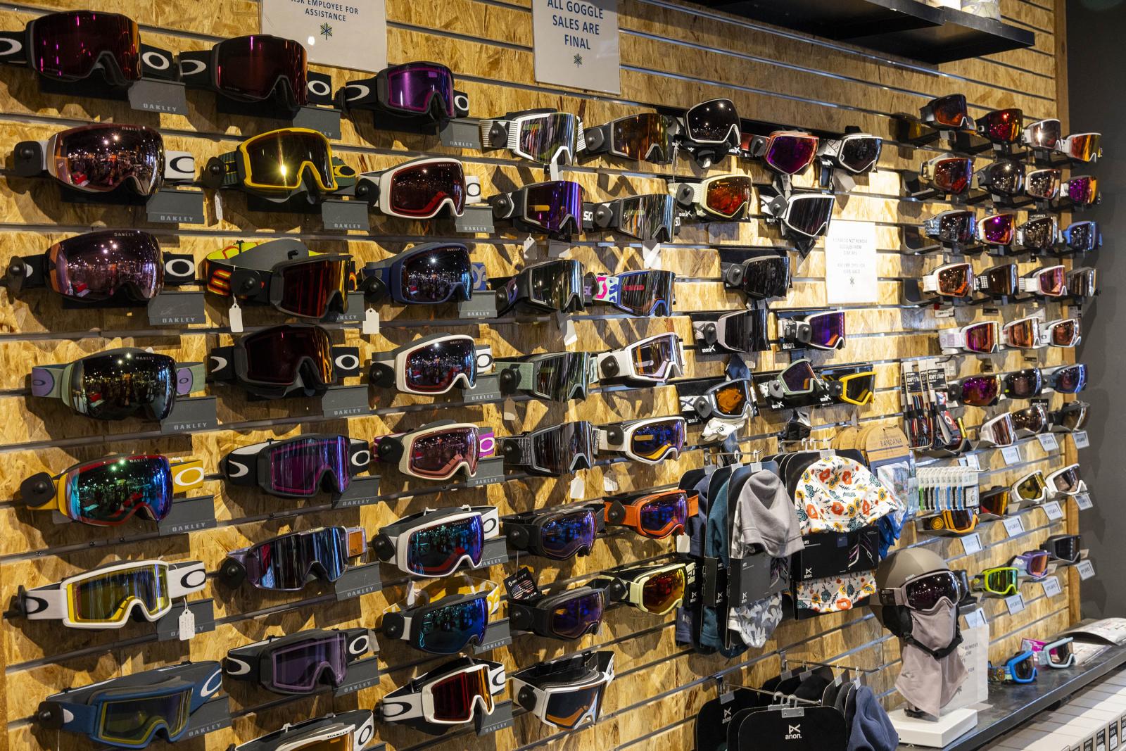Sunglasses and goggles displayed on a store wall.