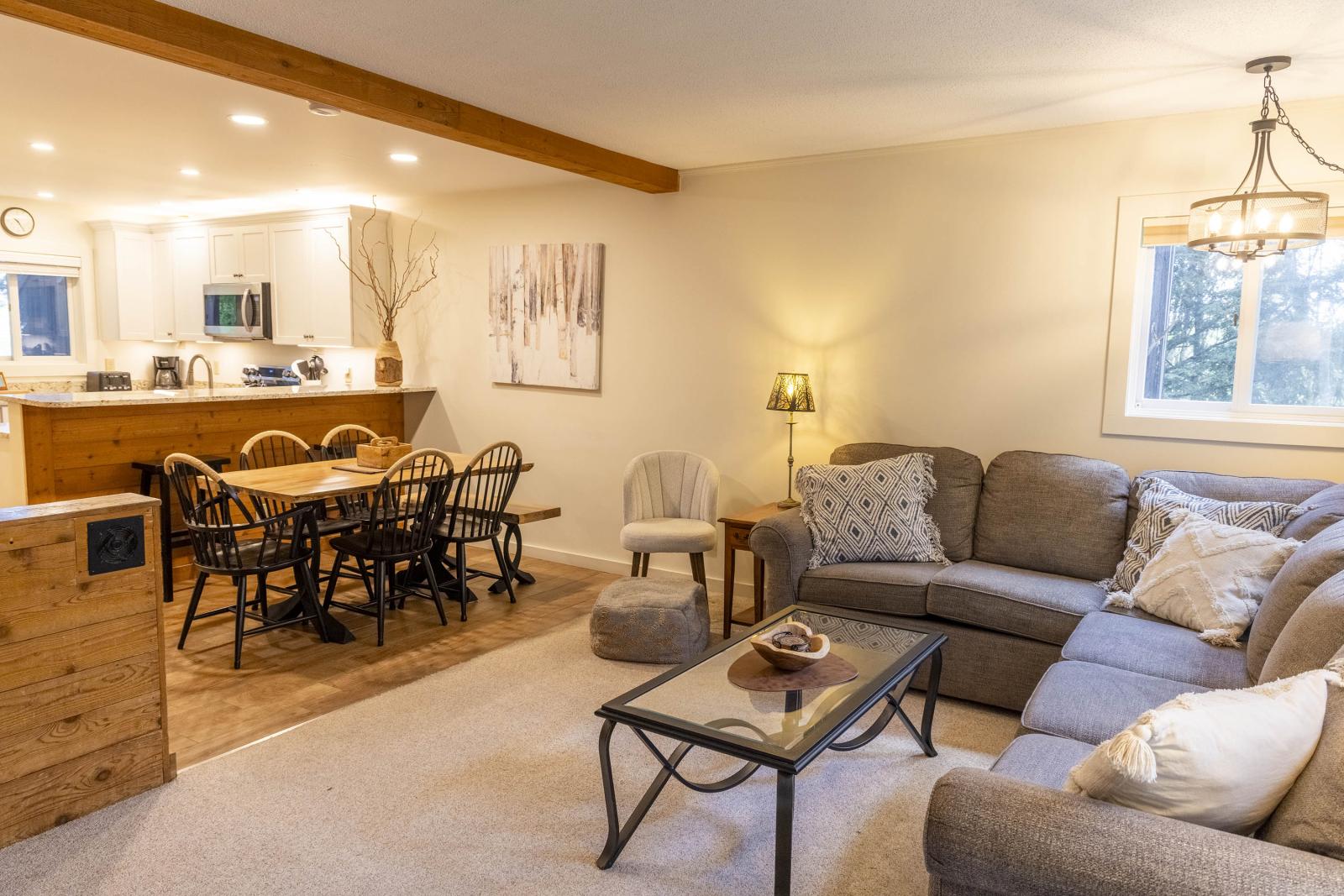 Cozy living room with sofa, dining table, and warm lighting.