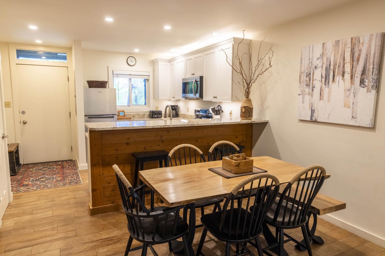 Cozy kitchen and dining area with wooden furniture and warm lighting.
