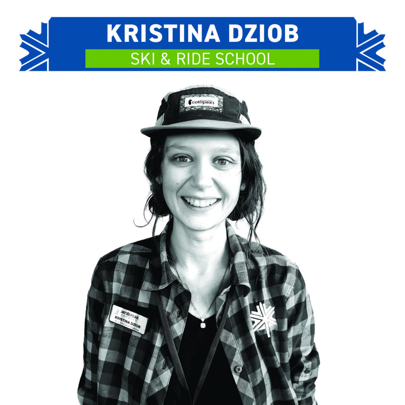 Smiling person in a cap and plaid shirt, with a badge.