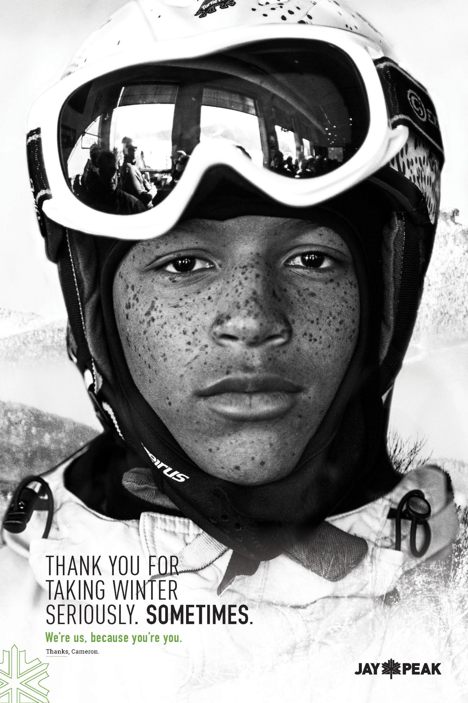 Young skier with helmet and goggles, serious expression, black and white photograph.