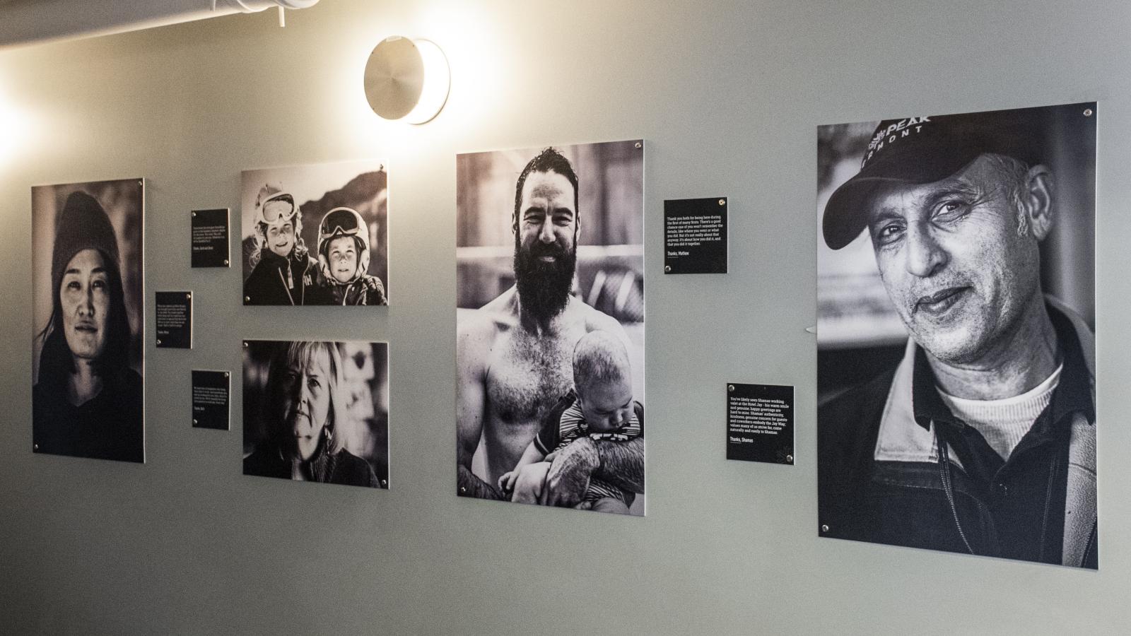 Black and white portraits hung on a wall in a gallery setting.