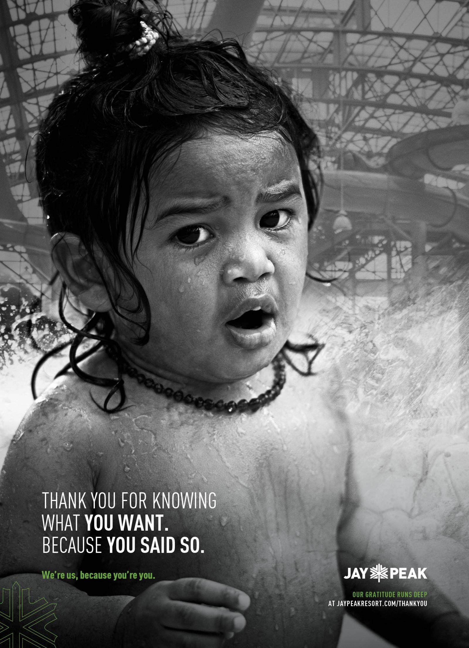 Young child with wet hair looks surprised in a pool, black and white photo.