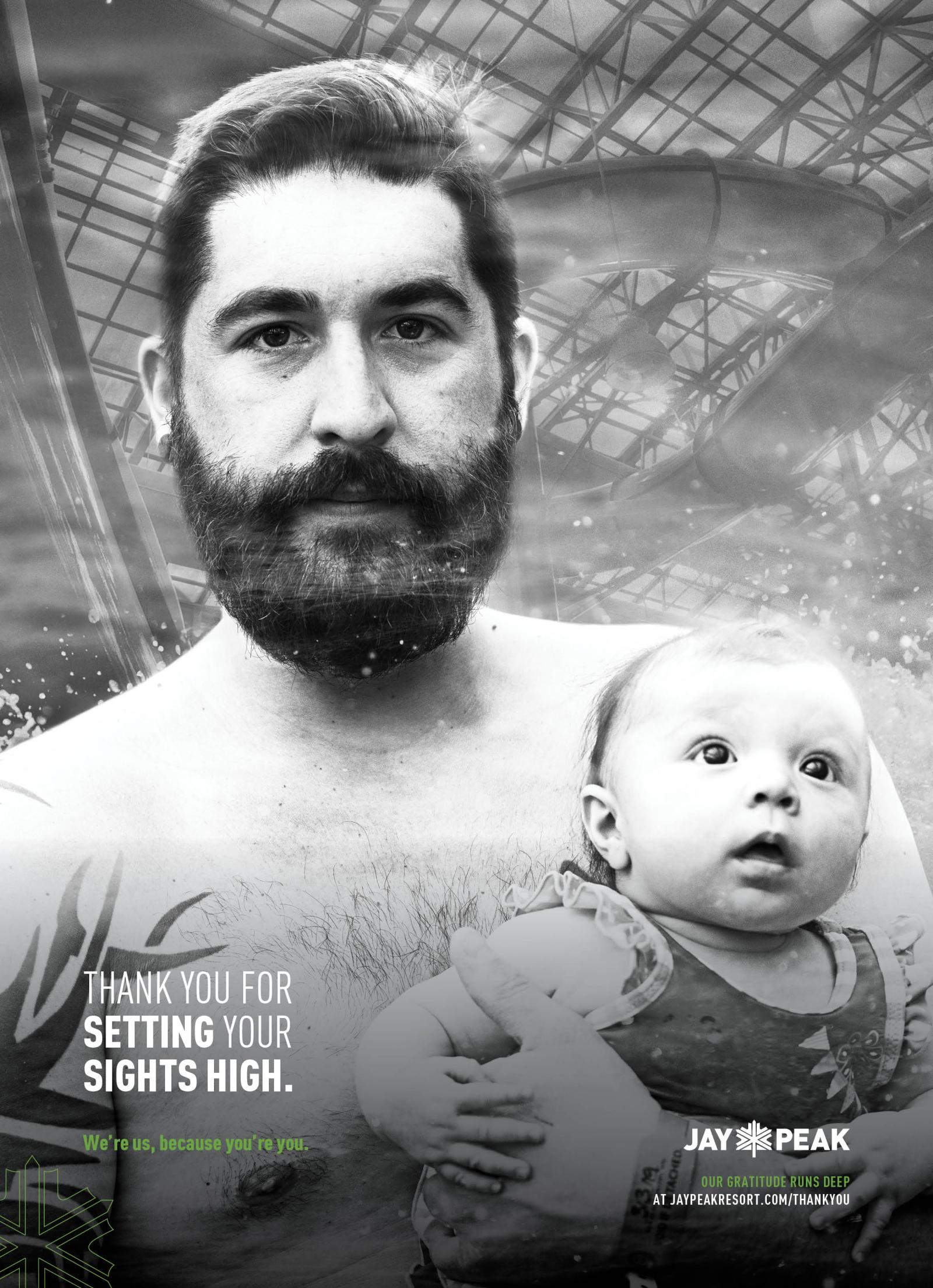 Father holding baby in black and white photo, expressions are calm.