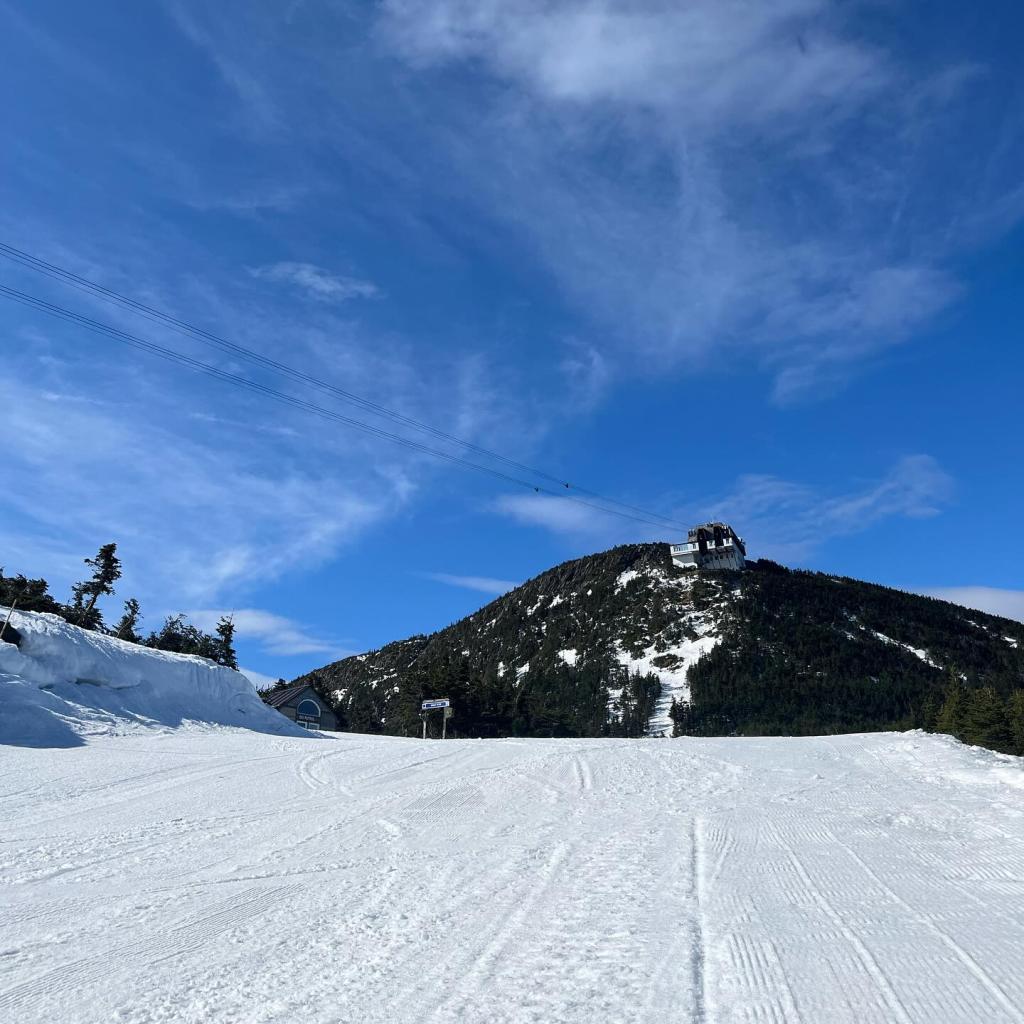 Snowy mountain slope under a clear blue sky.