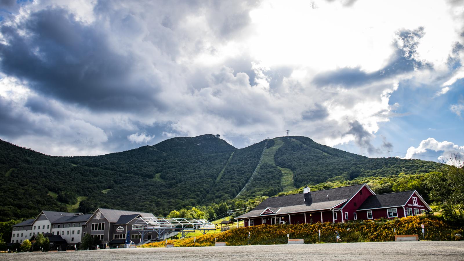 Mountain landscape with cloudy sky and buildings below.