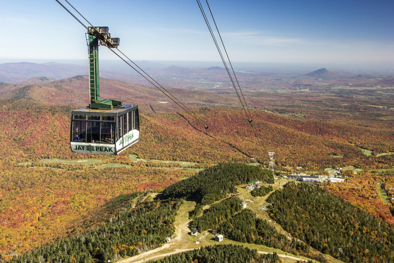 Aerial tram over colorful autumn forested mountains.
